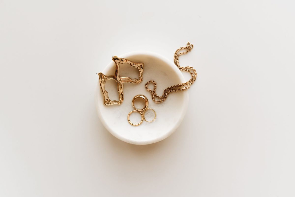 Bagues et bijoux dorés posés sur un marbre