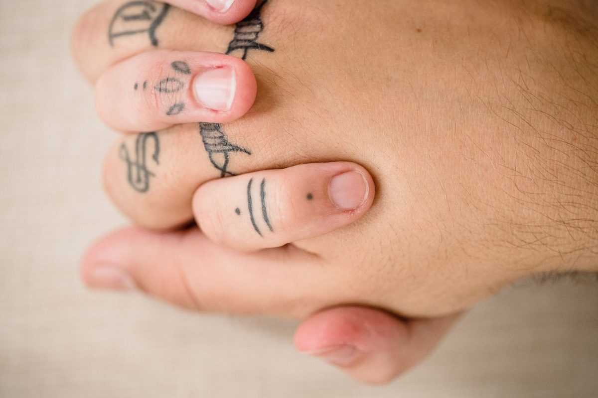 Mains tatouées et bijoux, en gros plan