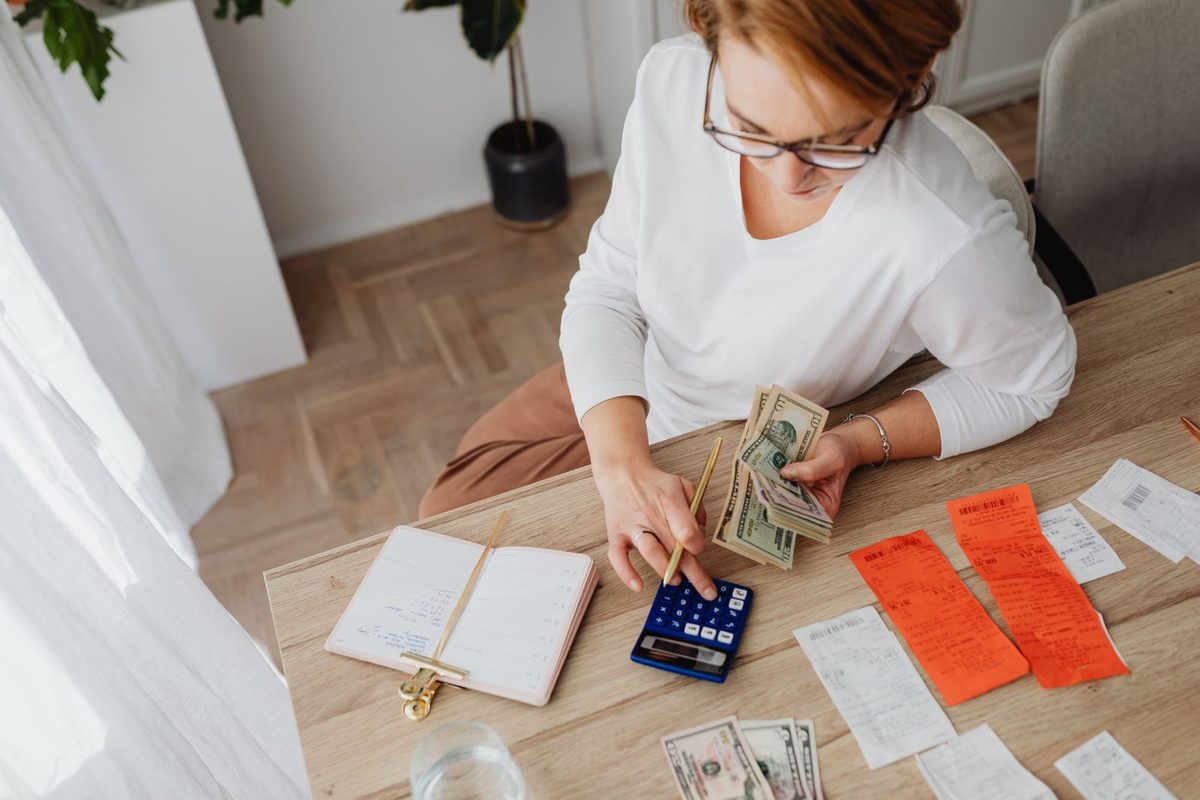 Personne organisant billets, reçus et calculatrice