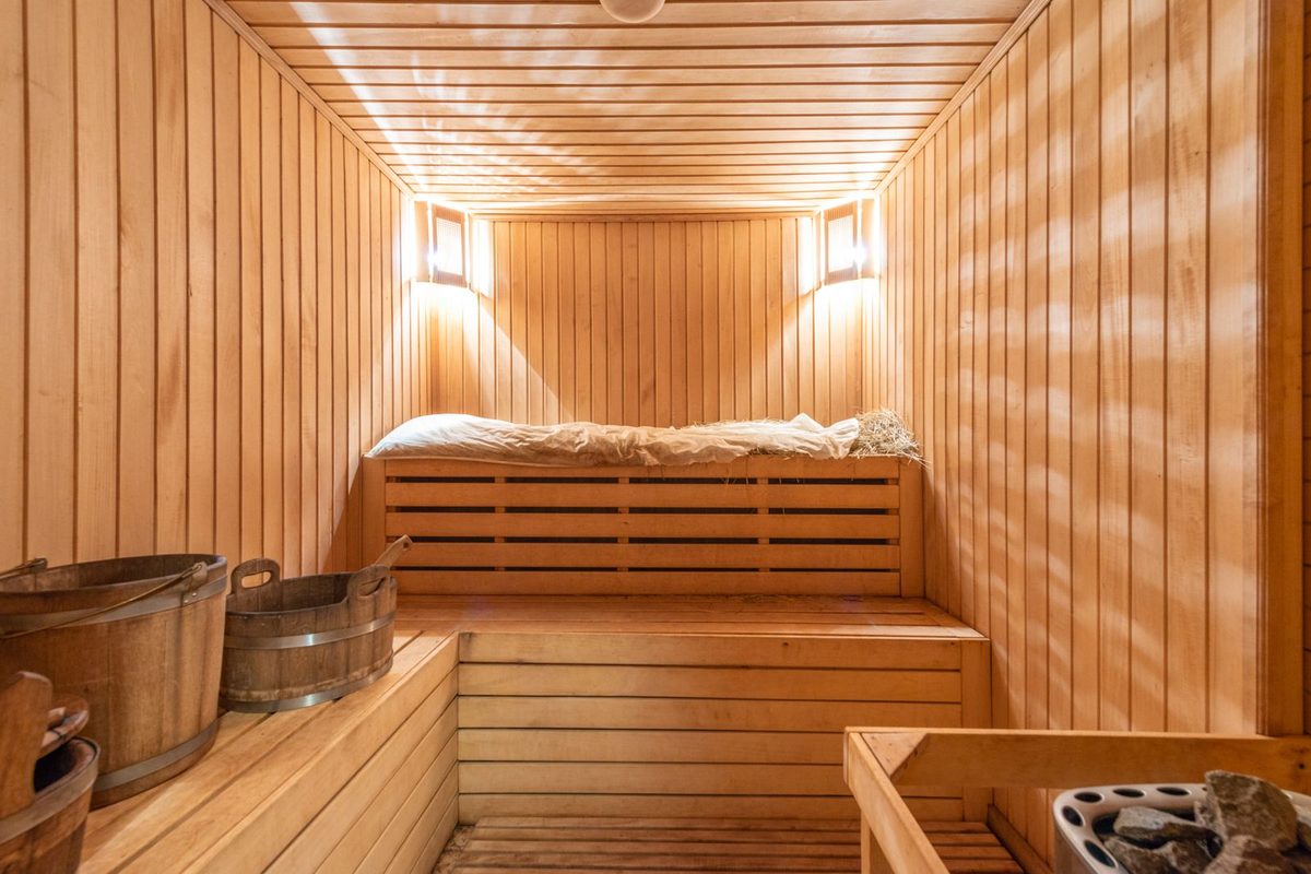 Cabine de sauna en bois clair, banquettes et éclairage tamisé