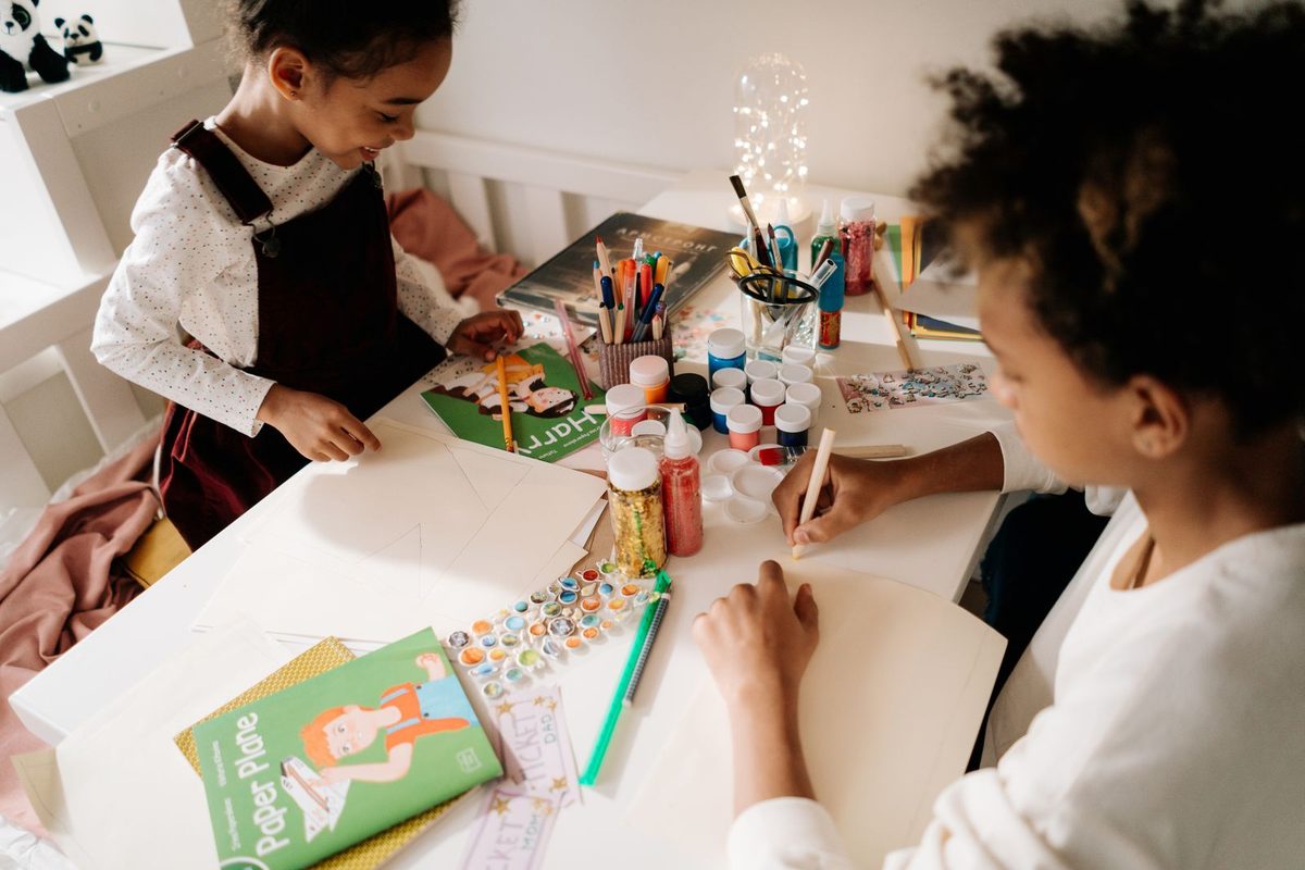 Deux enfants occupés à une activité manuelle sur une table