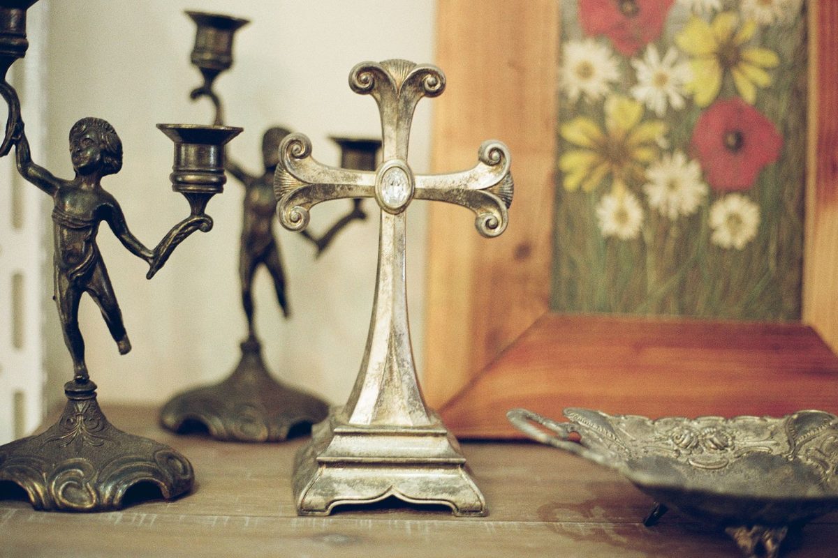 Croix ancienne et bougeoirs en métal posés sur un meuble