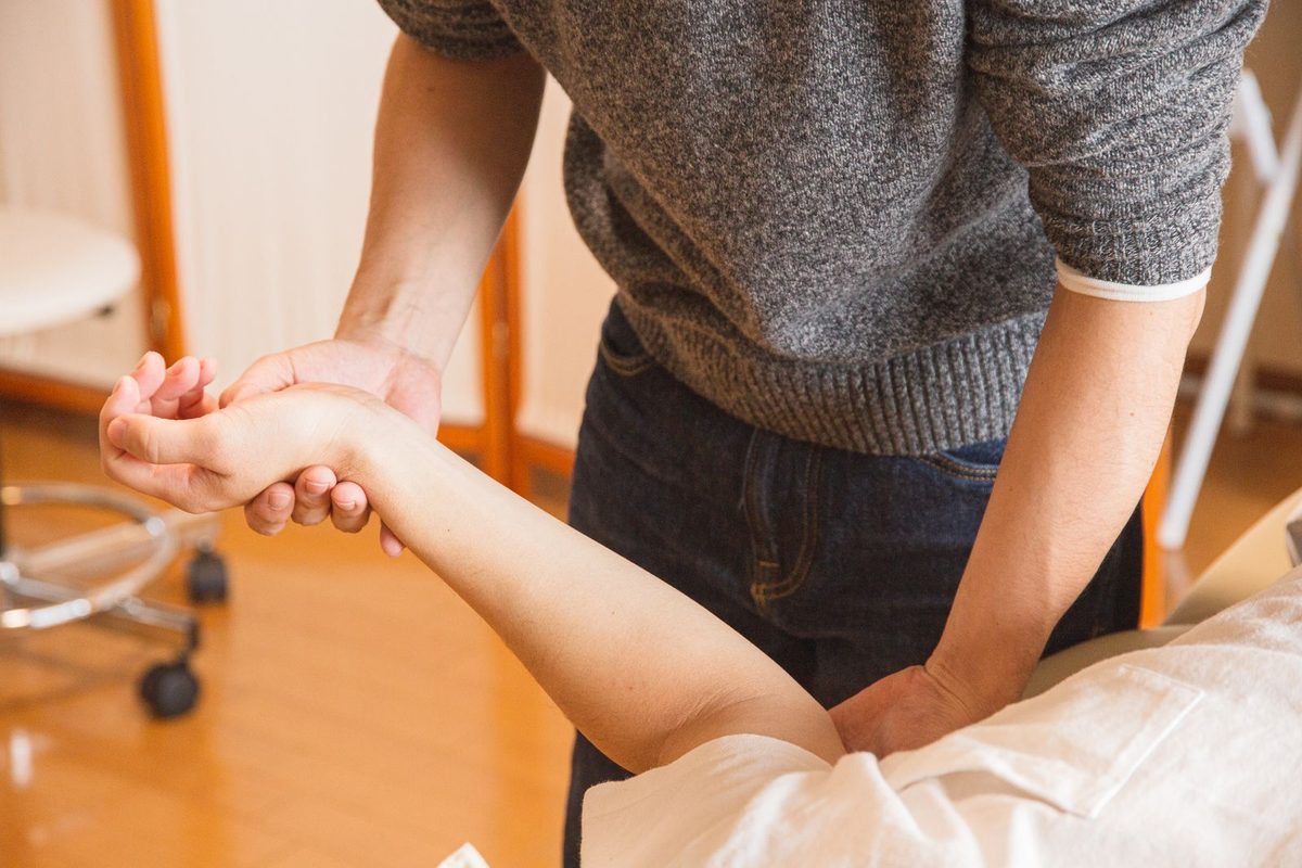 Praticien manipulant le poignet d'un patient