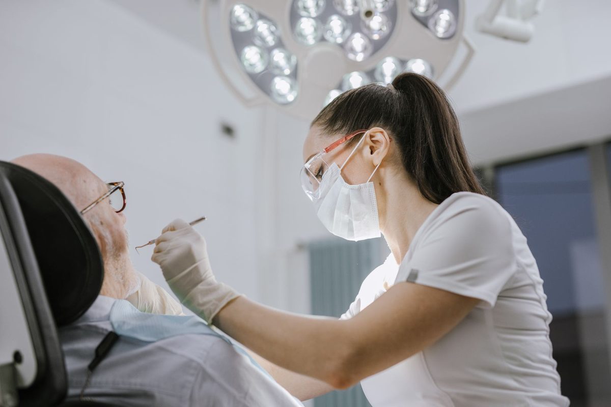 Dentiste intervenant sur un patient installé au fauteuil
