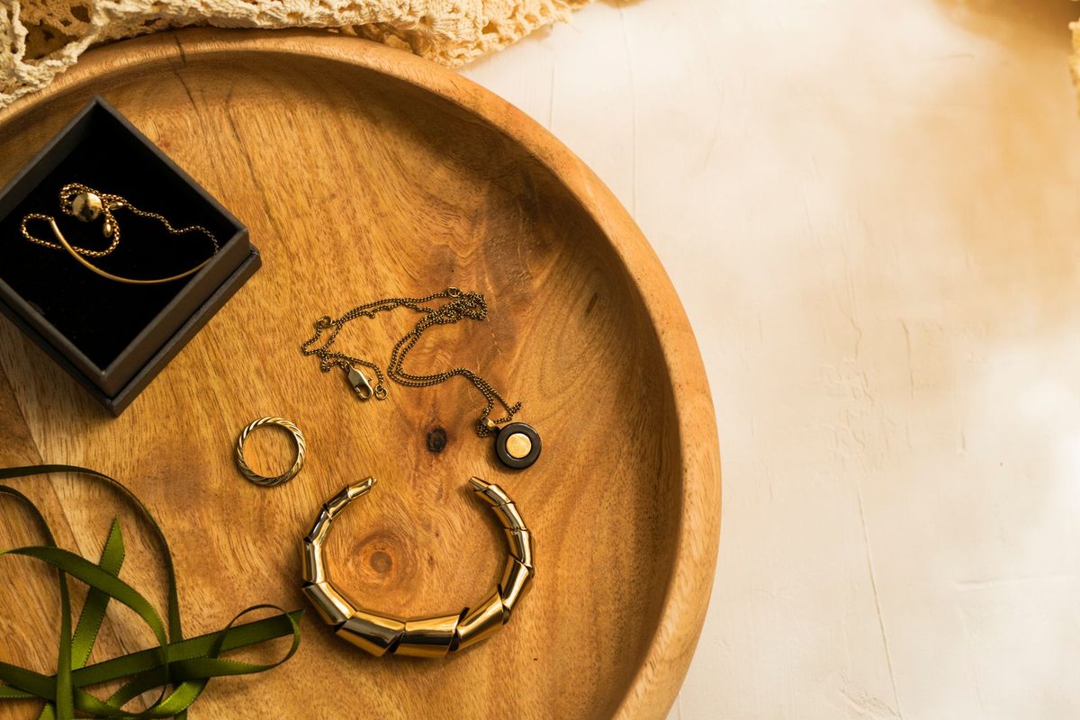 Bijoux dorés disposés sur un plateau en bois