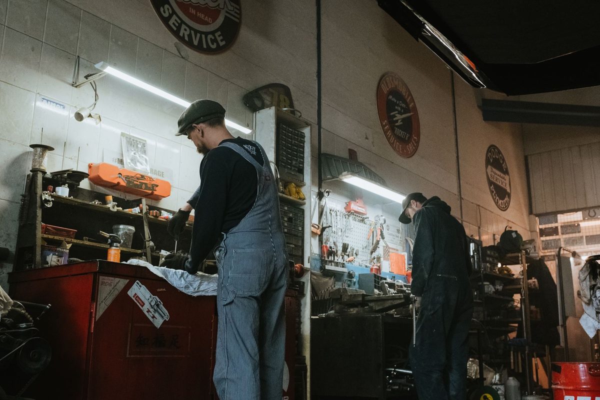 Deux mécaniciens au travail dans un atelier de carrosserie