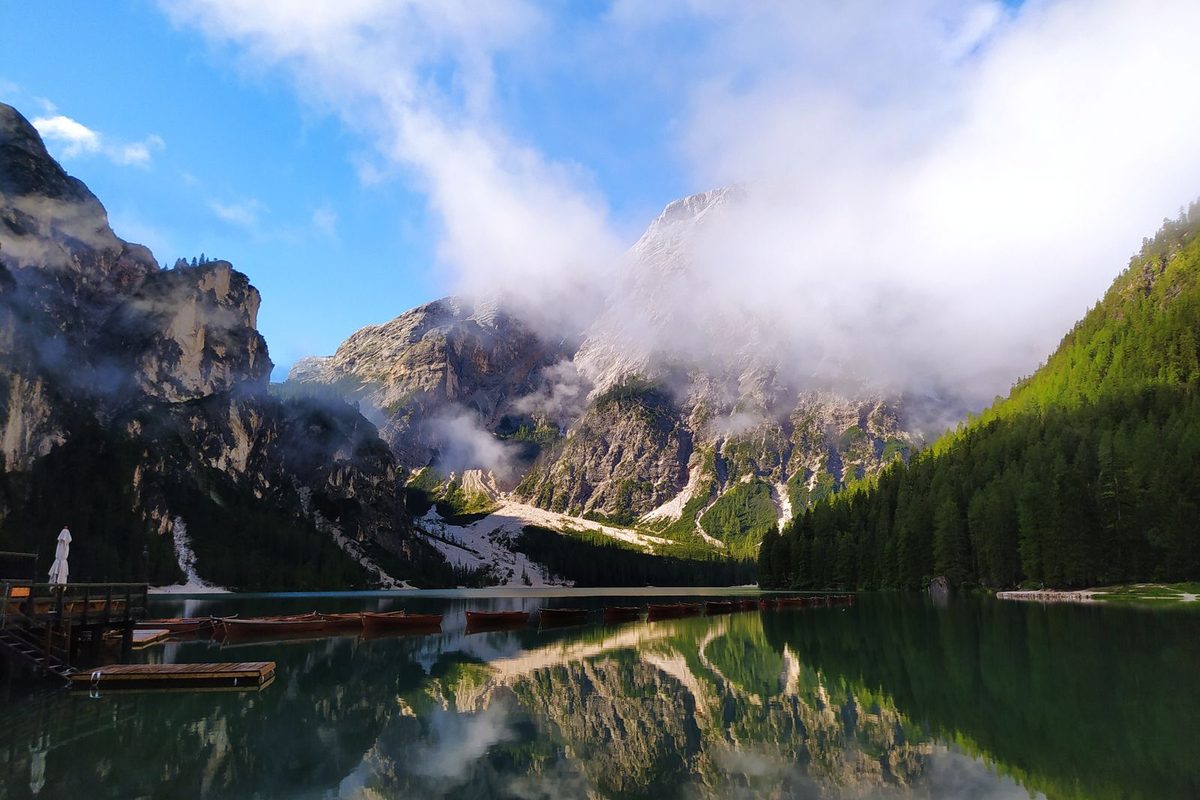 Lac de montagne parfaitement calme reflétant des sommets pris dans les nuages
