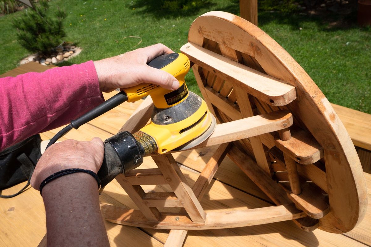 Ponçage à la ponceuse électrique d'un plateau de table en bois