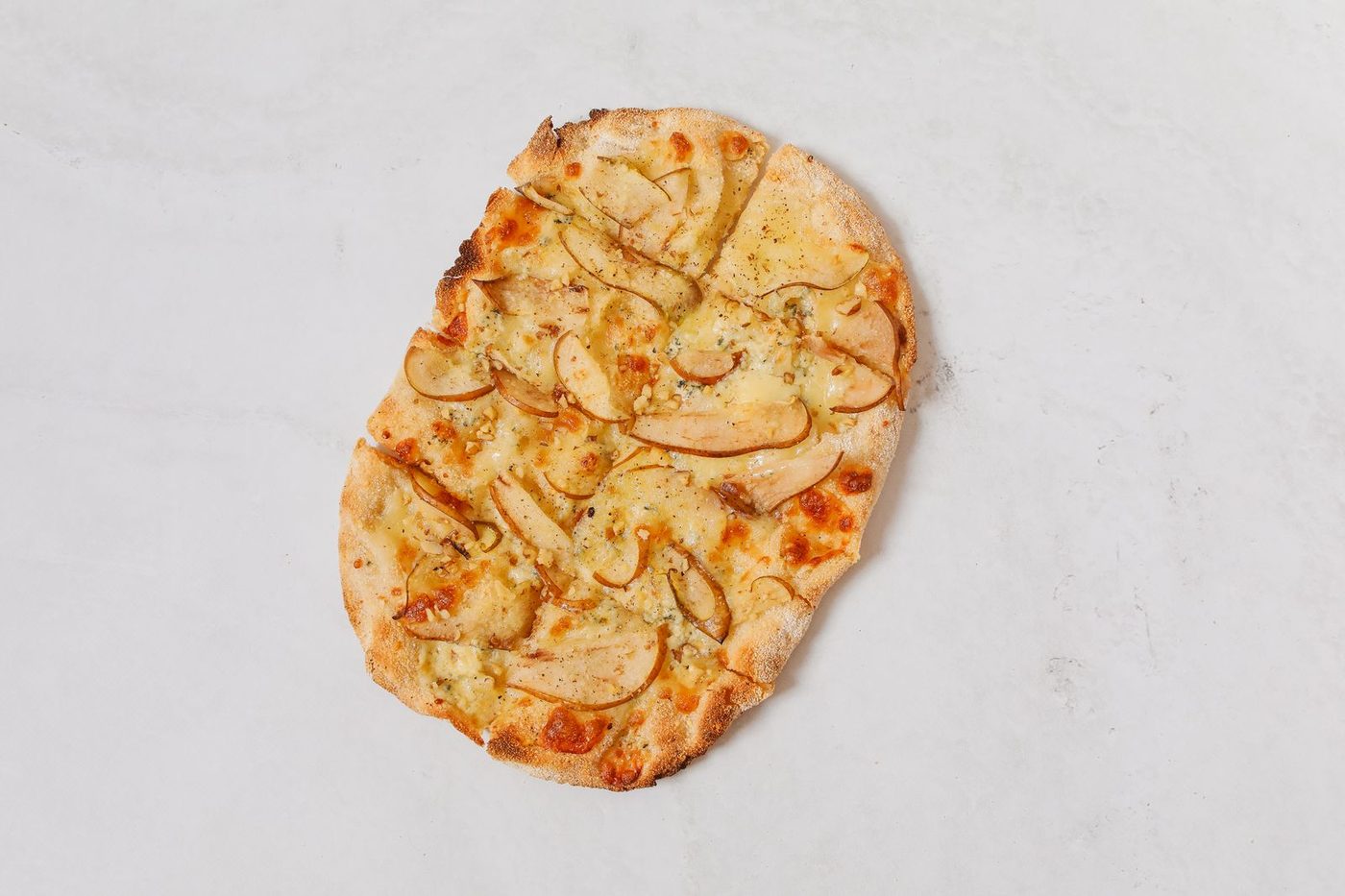 Tarte flambée alsacienne posée sur un plan de travail clair