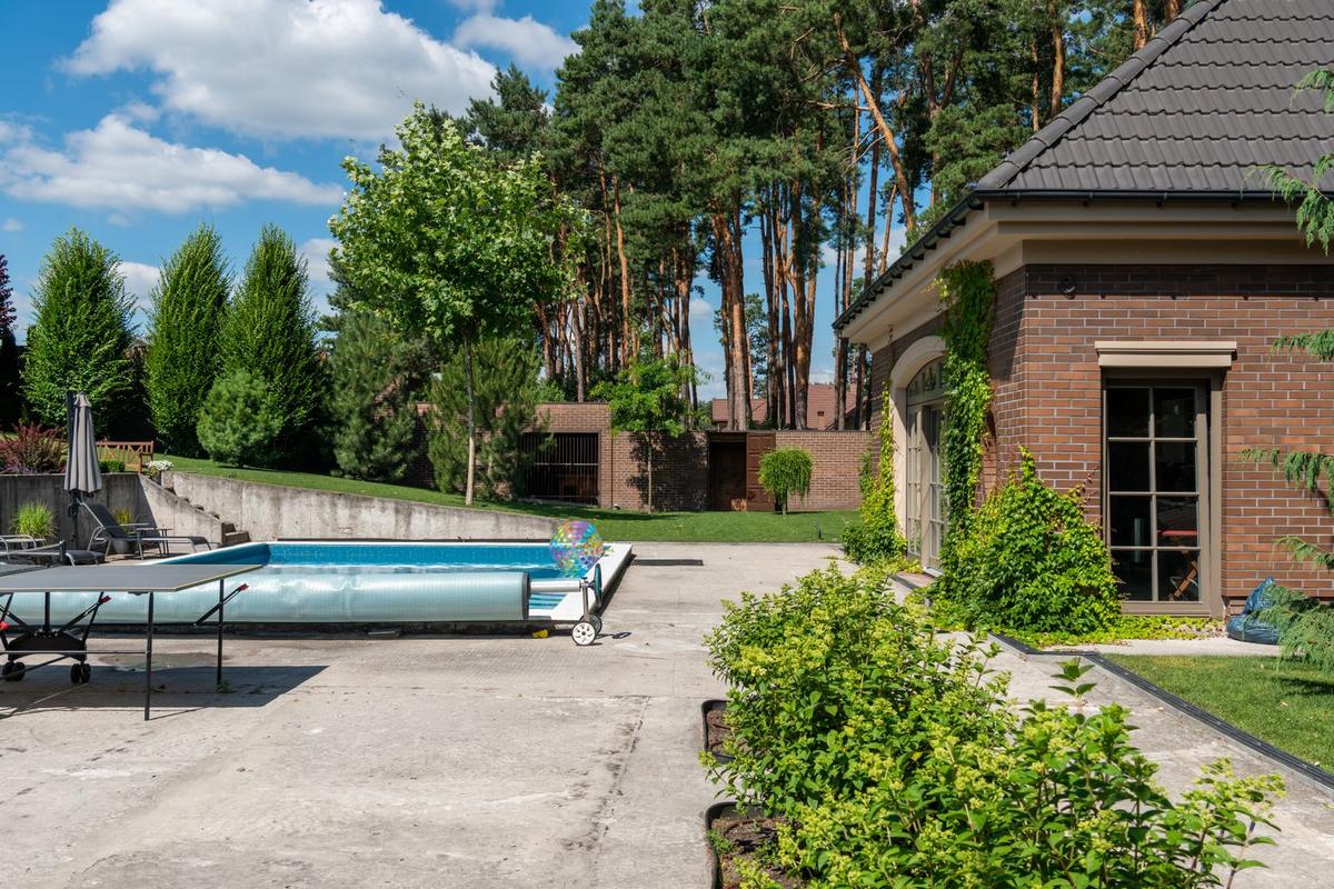 Piscine couverte d'une bâche dans un jardin en fin de saison