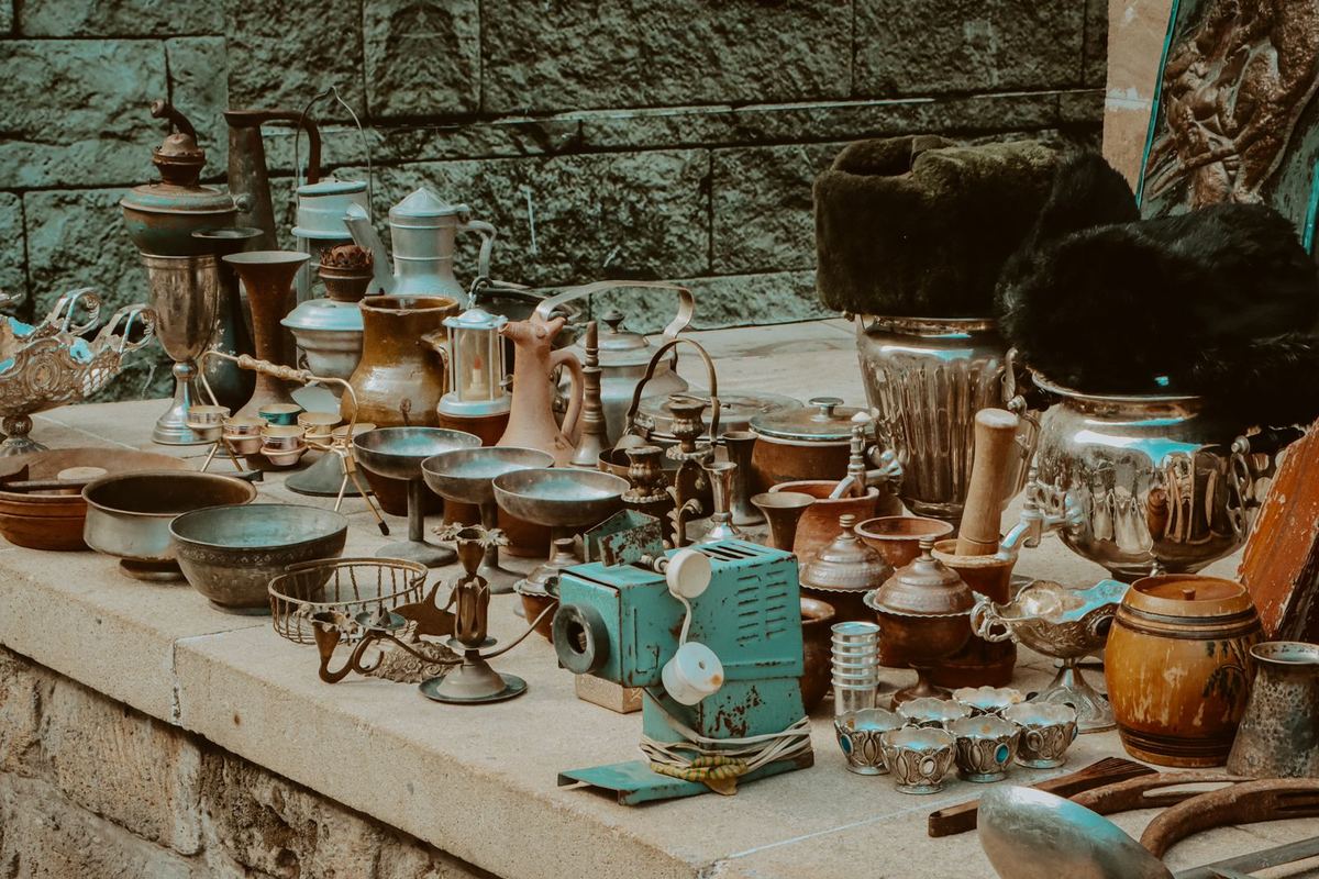 Étal de brocante couvert de vaisselle ancienne et d'objets chinés