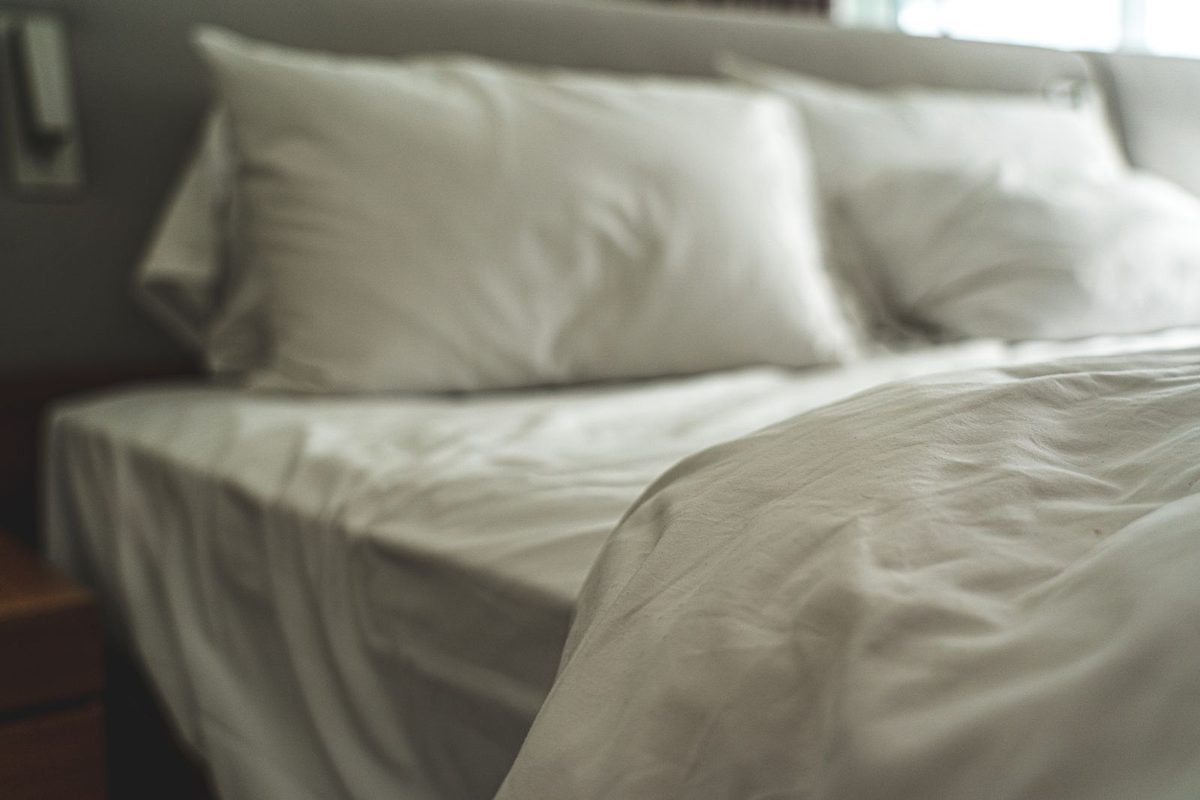 Linge de lit blanc et oreillers moelleux dans une chambre claire