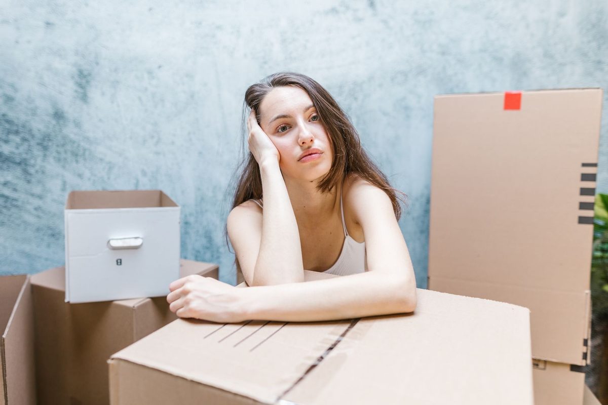 Personne assise au milieu de cartons de déménagement