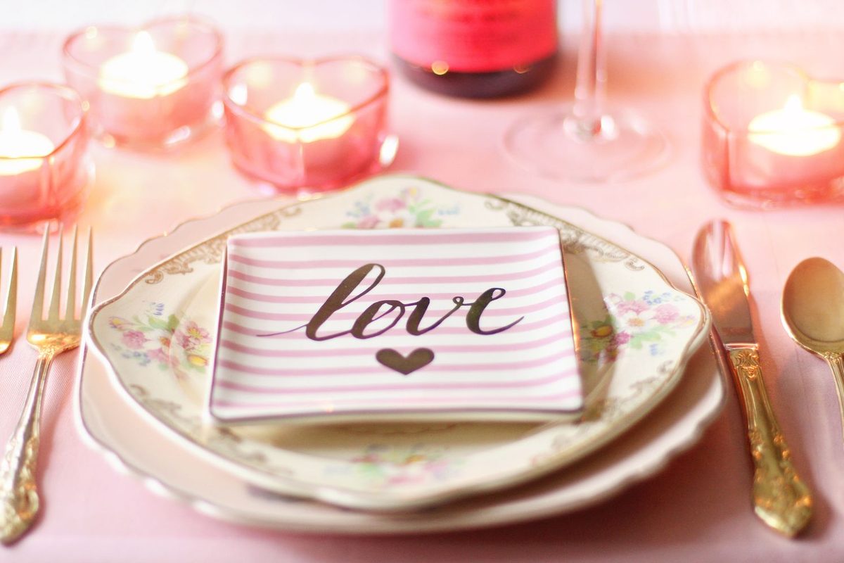 Table dressée pour un dîner en amoureux, bougies et couverts dorés