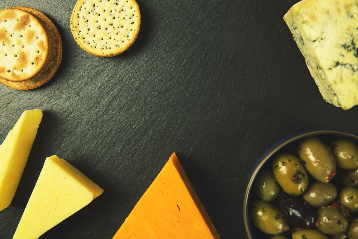 Plateau de fromages accompagné de crackers et d'olives