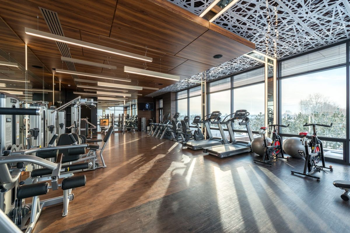 Salle de sport vitrée équipée de tapis et de vélos