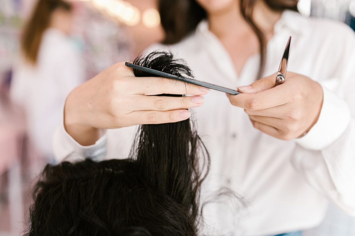 Coiffeuse coupant une mèche aux ciseaux