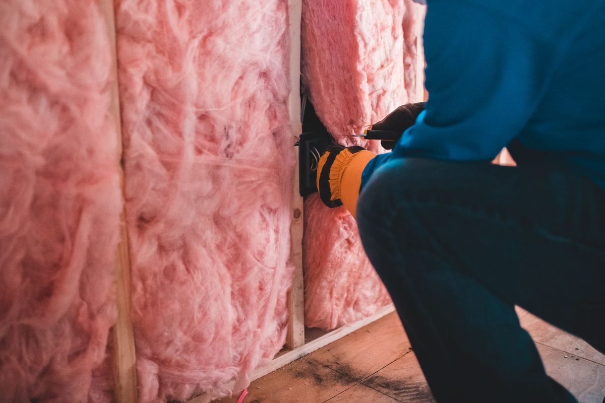 Pose d'un isolant en laine minérale par un artisan ganté