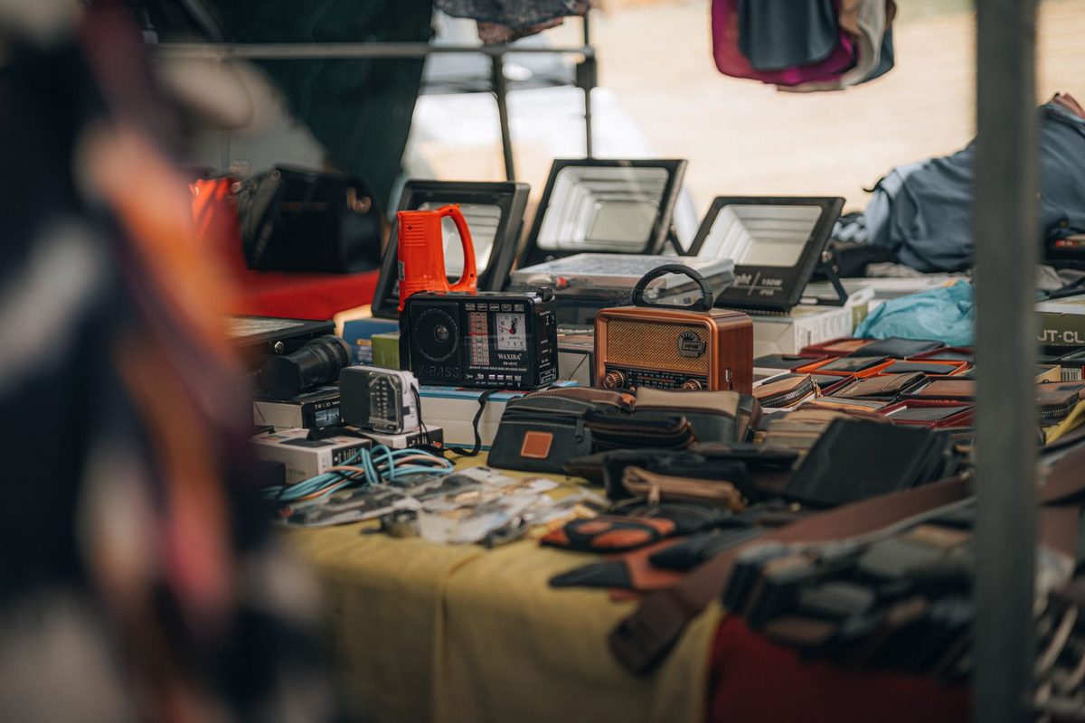 Étal de brocante couvert d'objets anciens et d'électronique