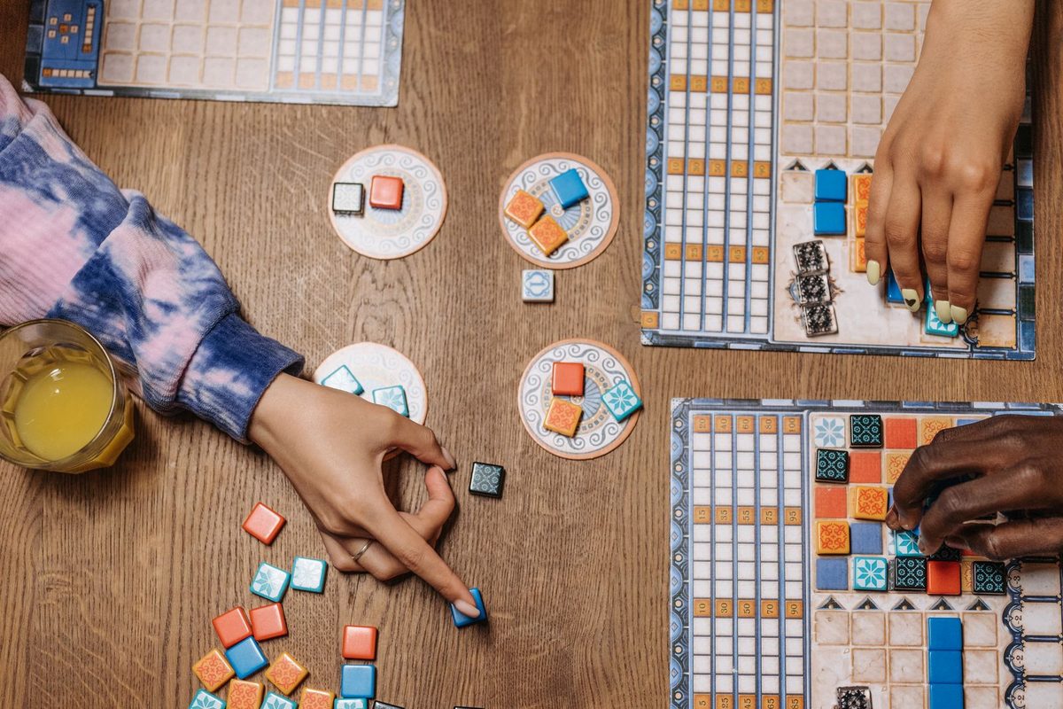 Plateau de jeu vu de dessus, avec pions et jetons entre plusieurs joueurs