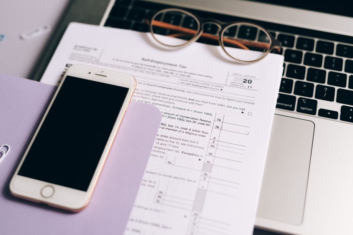 Documents administratifs, lunettes et téléphone posés sur un bureau