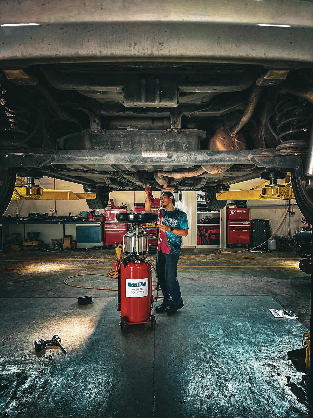 Bac de vidange sous voiture avec bidon d'huile moteur