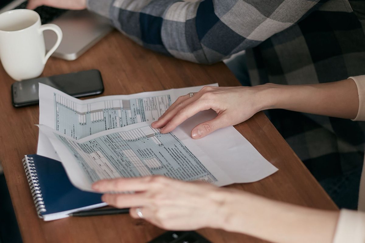 Mains classant des documents administratifs près d'une calculatrice