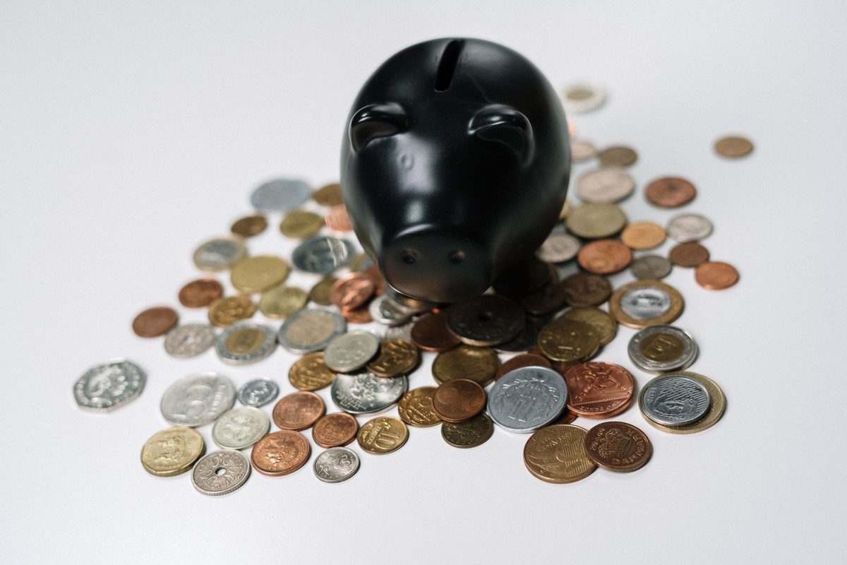Tirelire entourée de pièces de monnaie
