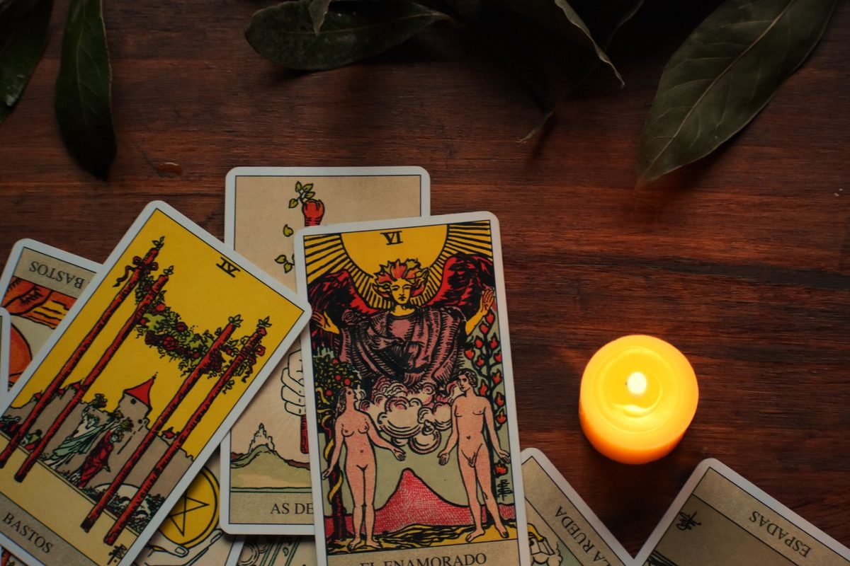 Cartes de tarot étalées près d'une bougie allumée