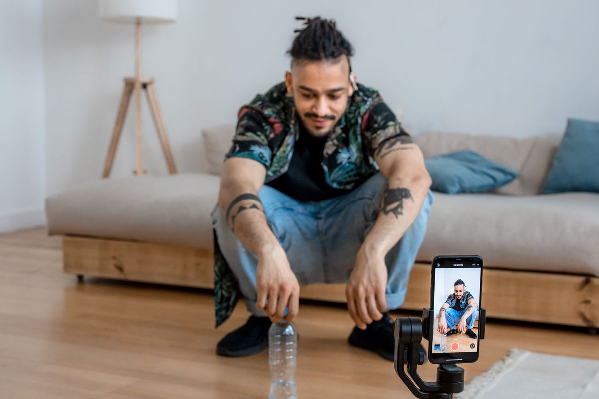 Créateur filmant une vidéo au smartphone monté sur trépied