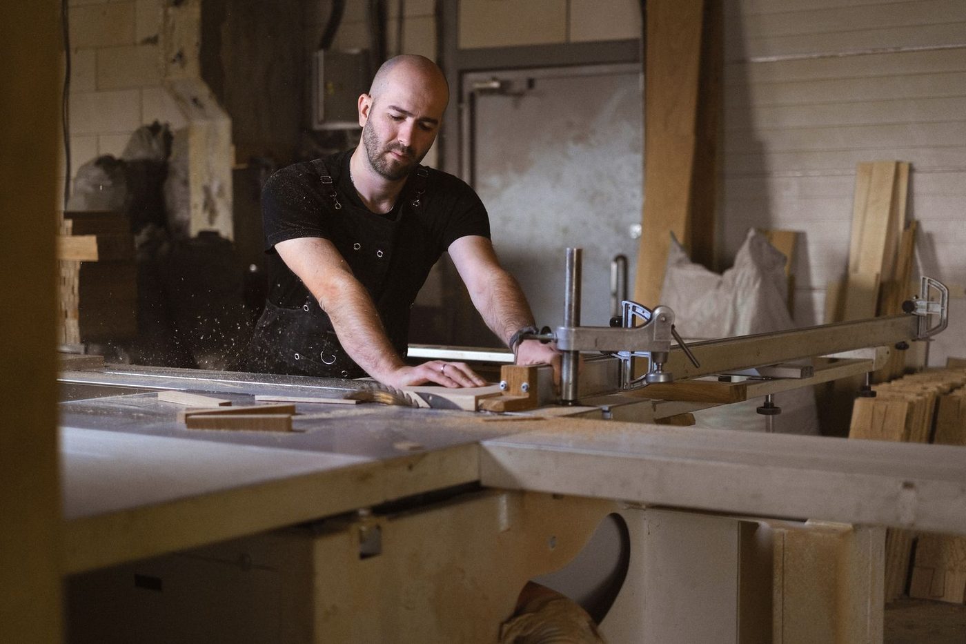 Menuisier travaillant une pièce de bois dans son atelier