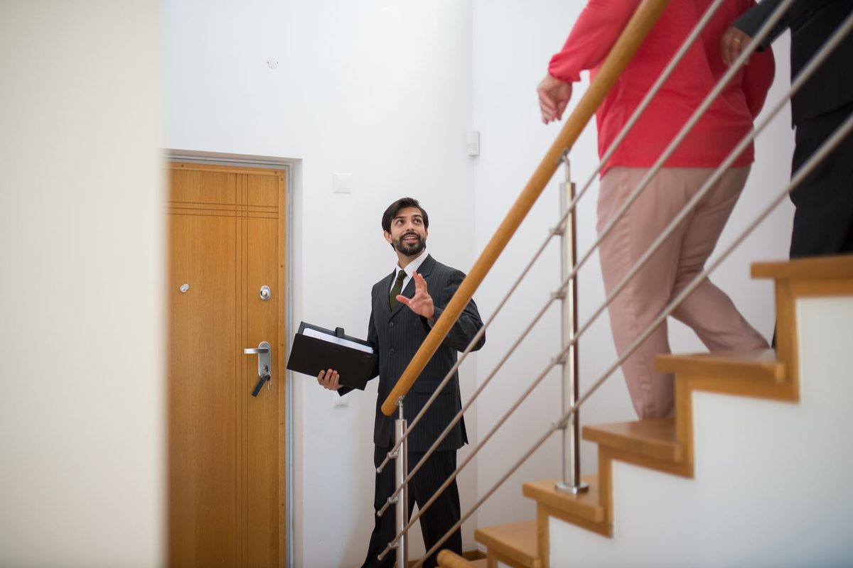Agent immobilier faisant visiter une maison à des acquéreurs
