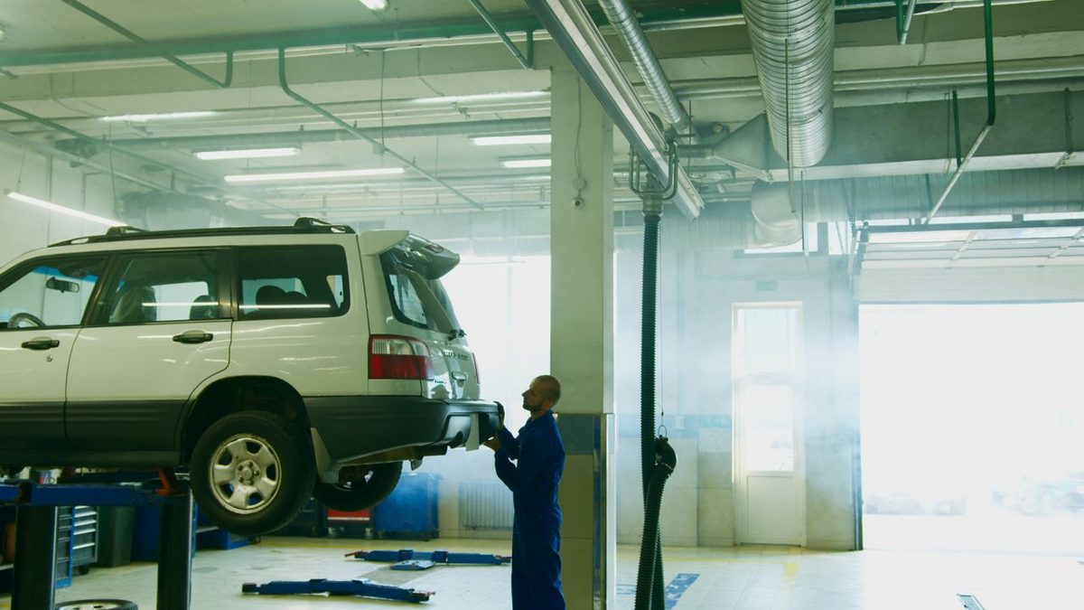 Technicien automobile utilisant une station de recharge de climatisation