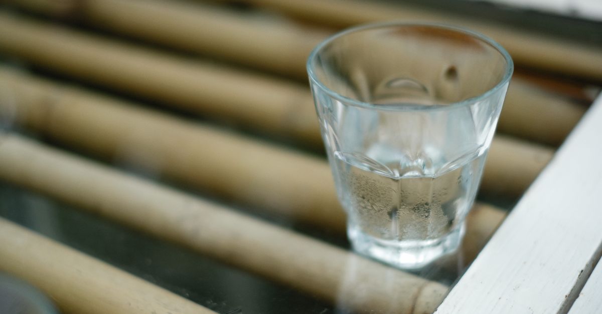 Verre d'eau fraîche posé sur une table en bois