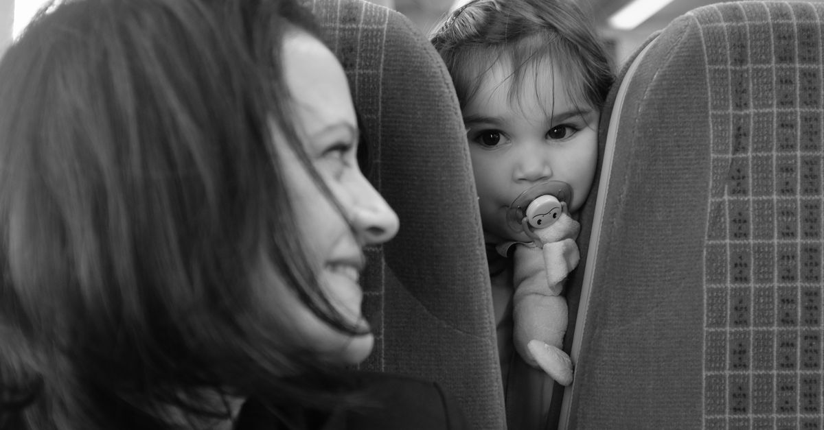 Bébé endormi dans les bras d'un parent en avion