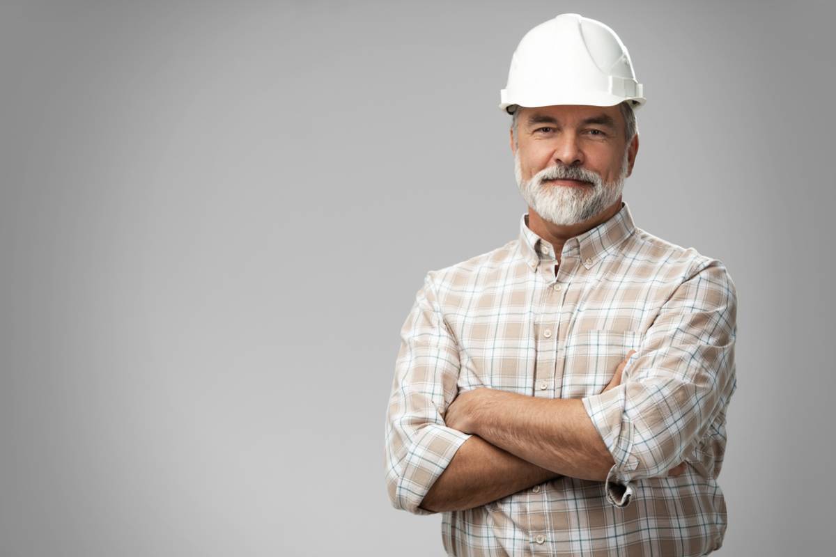 Artisan du bâtiment en casque blanc, bras croisés