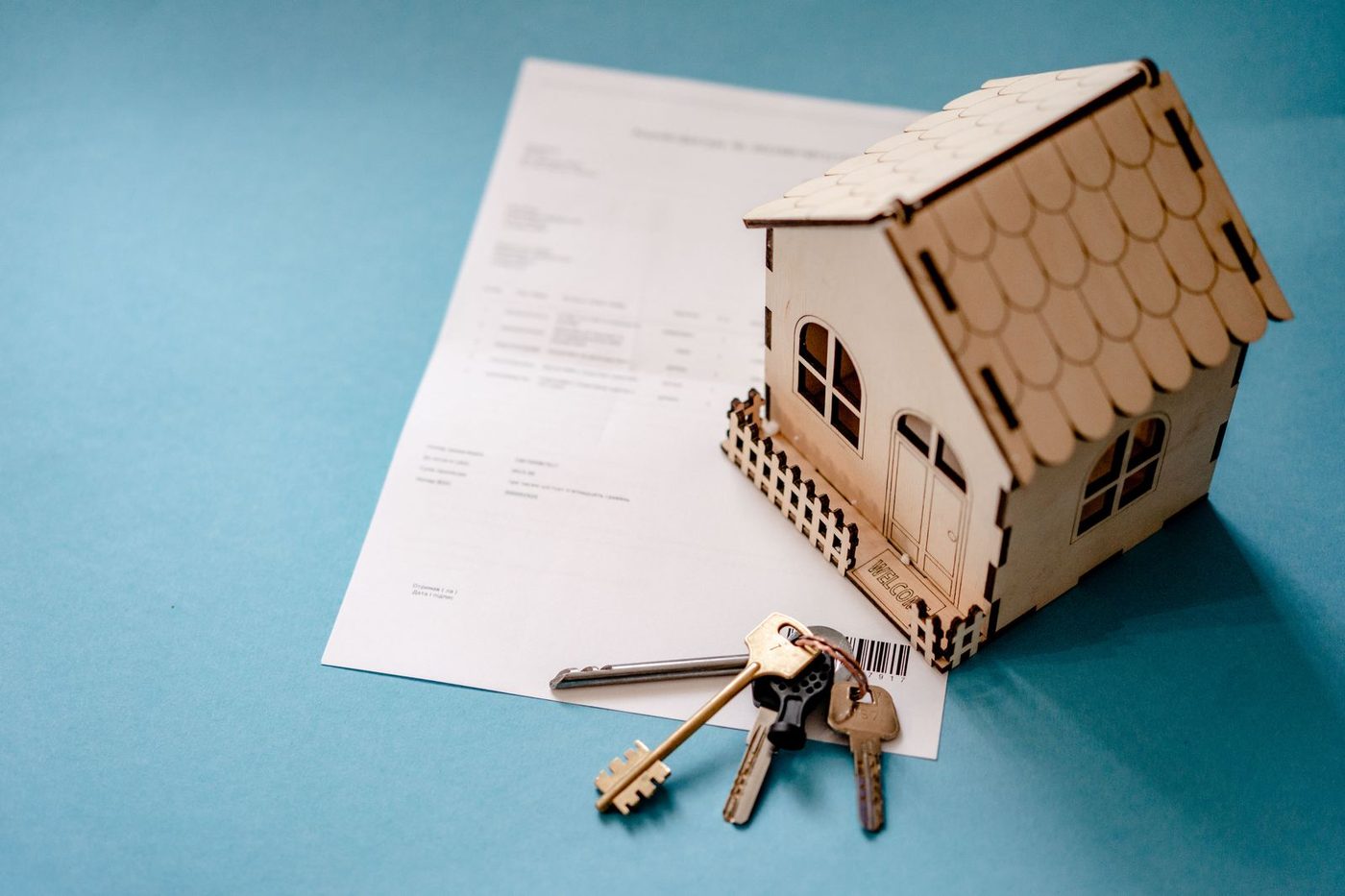 Maquette de maison en bois et trousseau de clés posés sur un document