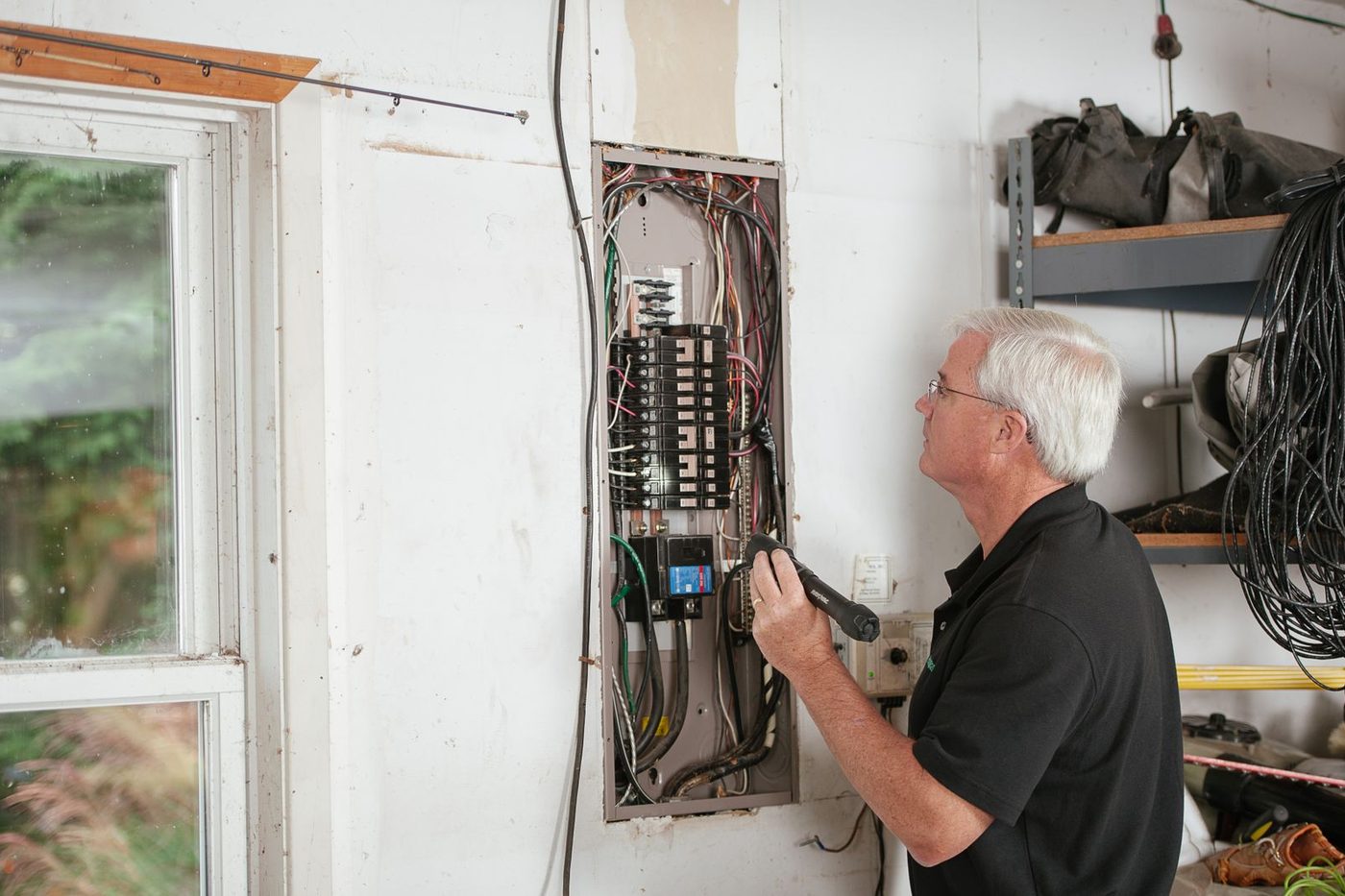 Électricien contrôlant un tableau électrique dans une maison