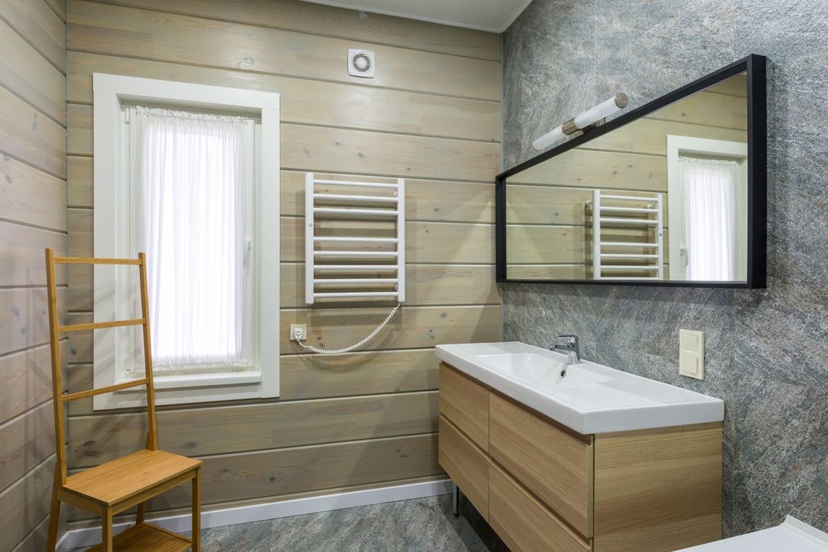 Sèche-serviettes mural près d'une fenêtre dans une salle de bains