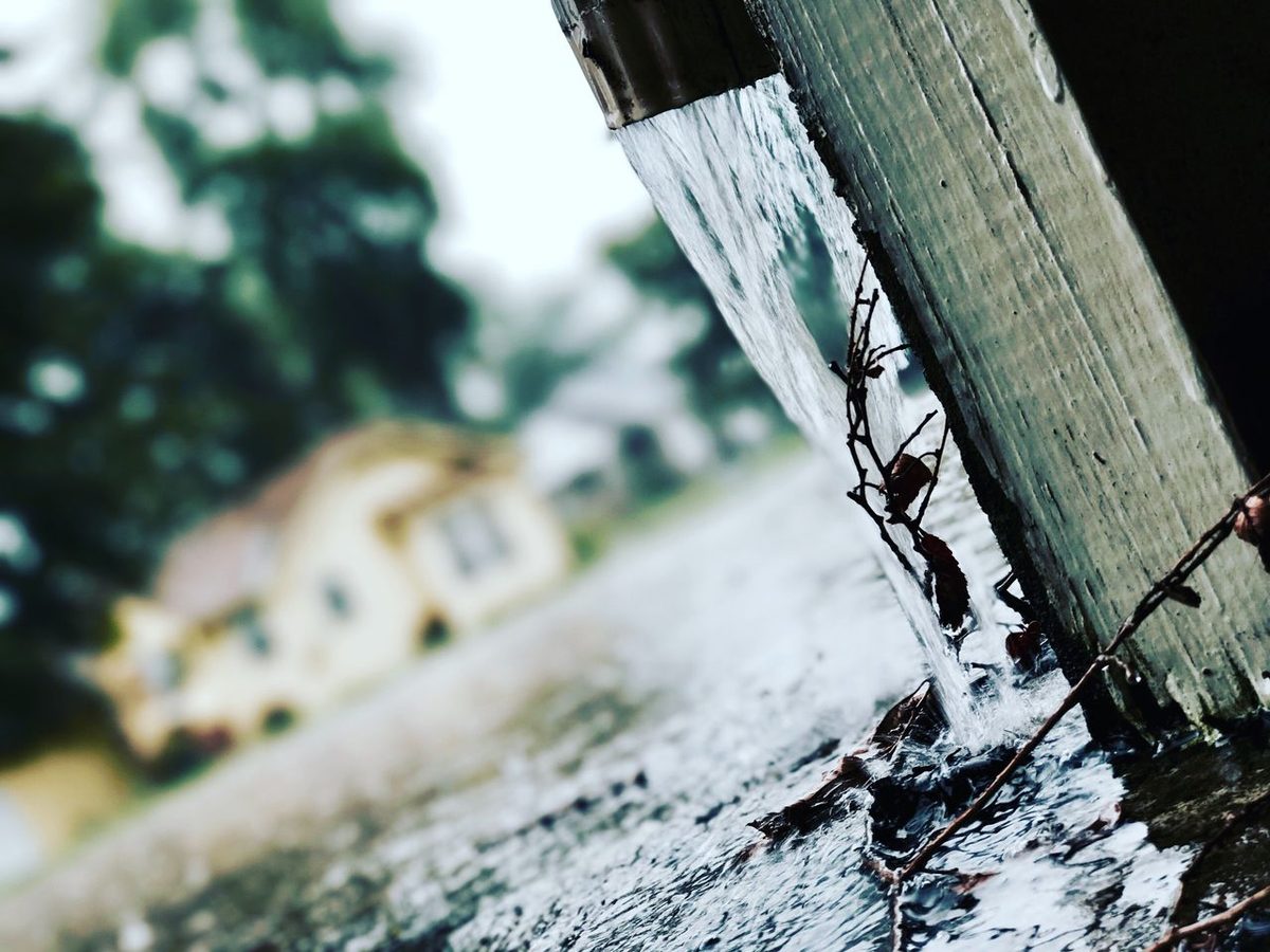 Eau de pluie s'écoulant d'une gouttière lors d'une averse